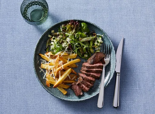 Biefstuk tagliata met parmezaanfriet en groene salade met courgette