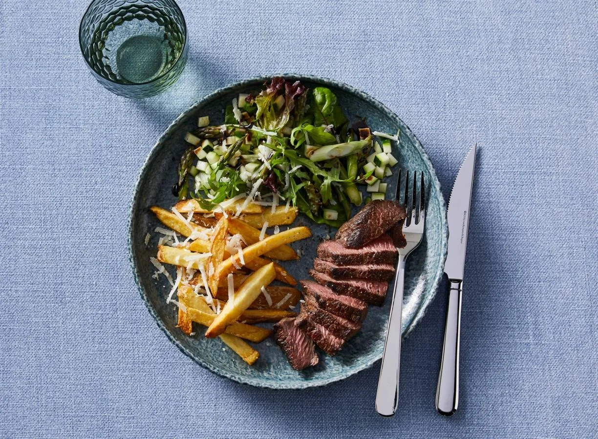Biefstuk tagliata met parmezaanfriet en groene salade met courgette
