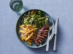Biefstuk tagliata met parmezaanfriet en groene salade met courgette