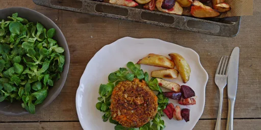 Beantastic burger op een bedje van veldsla met geroosterde bieten, pastinaak en aardappels