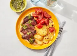 Biefstuk met pesto, aardappelschijfjes en tomatensalade