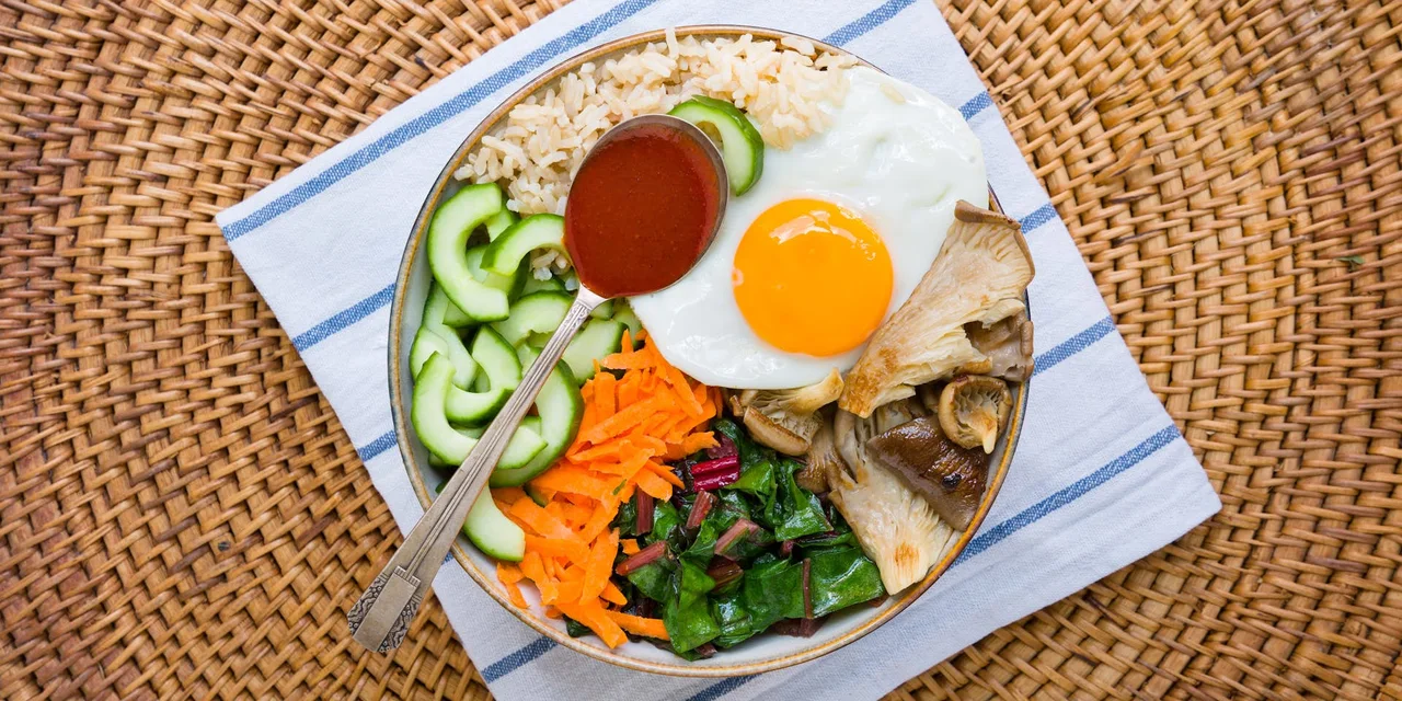 Bibimbap met snijbiet, oesterzwammen, komkommer, peen, spiegelei en Gochujang saus